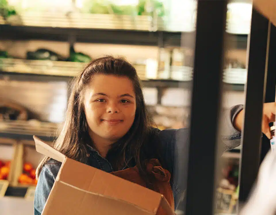 Convenience store employee with Down syndrome restocking food products